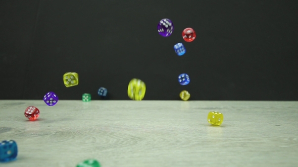Multicolored Dice Fall on a Black Background