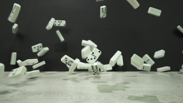 Shot of White Dominoes Fall on a Black Background