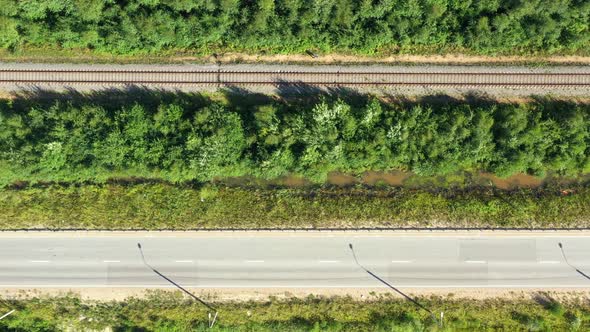 Asphalt Road and Train Railway at the Forest. Aerial View From Drone