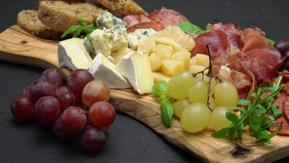 Meat and Cheese Plate Antipasti Snack with Prosciutto, Melon, Grapes and Cheese