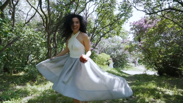 Young Laughing Woman with Red Apple Running Through Sunny Garden,