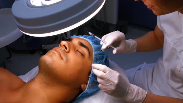 Doctor inserting facial injection on male patient face