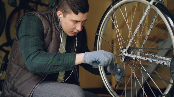 Serious Guy Experienced Master Is Fixing Bicycle Wheel