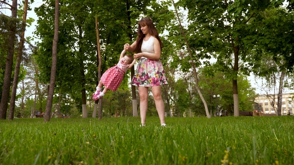 Mom Swings Happy Baby in His Arms Through Air