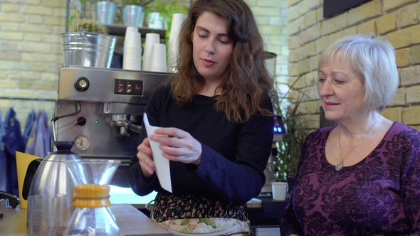 Barista Tells Mature Woman about Coffee Filters and How to Use Them