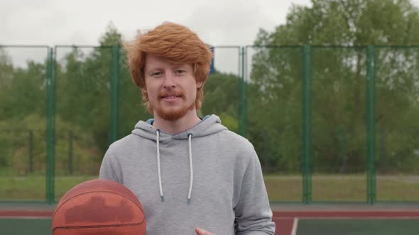 Young Man Posing with Basketball Outdoors