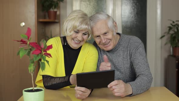 Pretty Mature Senior Couple Grandparents Making Video Call Message at Home