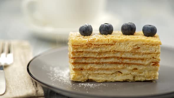 Cream Puff Pastry Cake, Decorated with Four Blueberries, Is Being Powdered with Icing Sugar. UHD