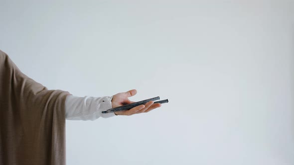 Jesus' Hand with Stigma Holds a Crucifixion Nail on a White Background