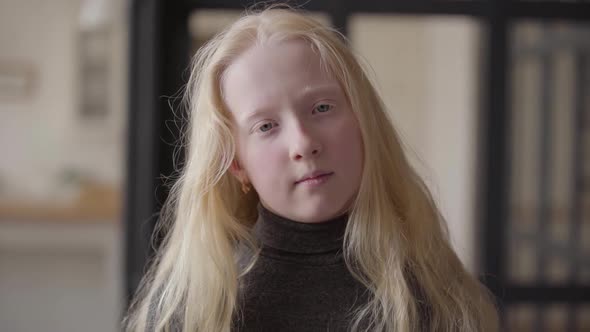 Portrait of an Albino Girl with Grey Eyes Looking at the Camera Smiling. Unusual Appearance