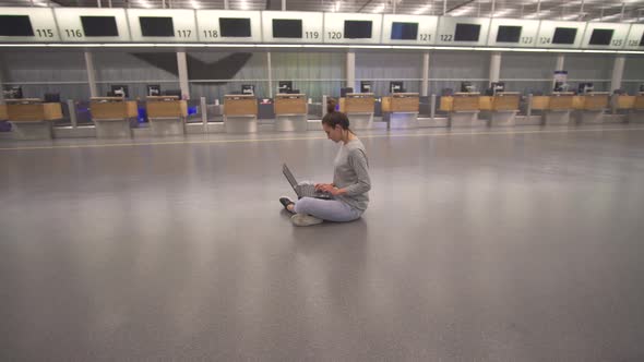 Woman Work on Laptop and Waiting for Flight in Airport in Terminal on the Floor