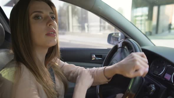 Attentive Female Driver Leaving Gas Station and Looking in Rearview Mirrors