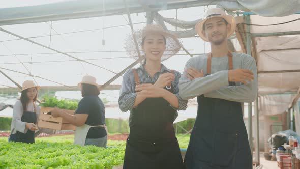 Portrait of Asian farmers couple work in vegetables hydroponic farm.