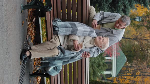 Vertical View of Happy Couple Caucasian Family Senior Man Sit Behind Woman on Bench Hugs Elderly