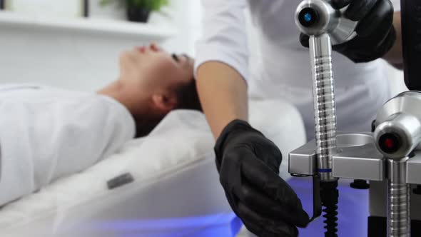 Face Massage  Therapist Uses Ultraviolet Light on a Woman's Face