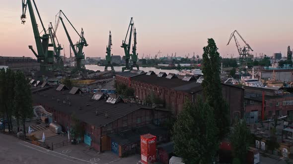 Buildings And Tower Cranes At The Shipyard In Gdańsk Port In Poland. aerial, forward
