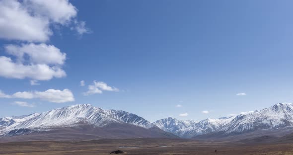 Timelapse of Sun Movement on Crystal Clear Sky with Clouds Over Snow Mountain Top