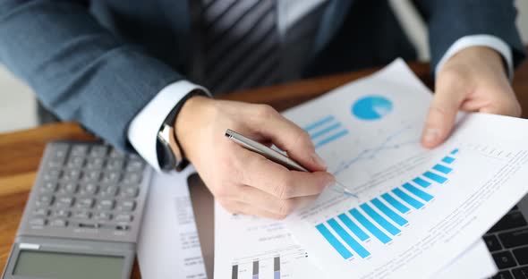 Businessman is Studying Financial Indicators in Graphs