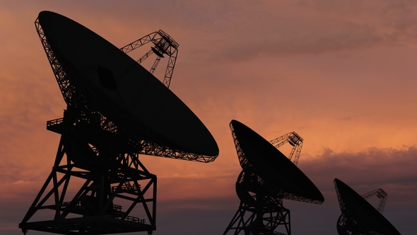 Satellite Dishes Moving in  Against a Sunset Sky