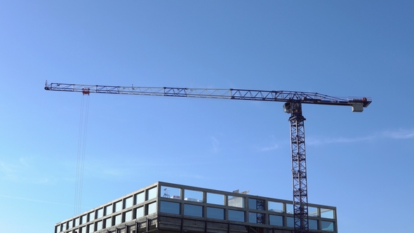 Construction Crane and Building on a Background of Clear Sky