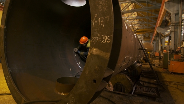 Worker Cuts Large Diameter Pipe with Circular Saw