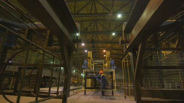 Man in Respirator Paints Metal Grid in Warehouse alt