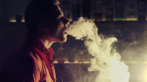 Young Man Smoking Hookah at a Bar