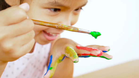 Asian child painting her hand