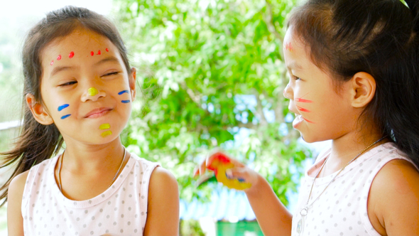 Two girls playing and having fun with their painting hand