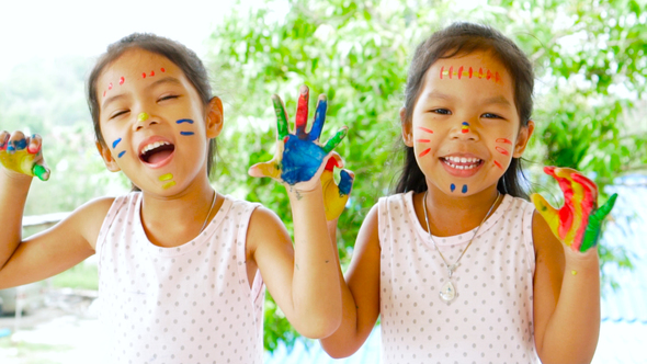 Two girls playing and having fun with their painting hand