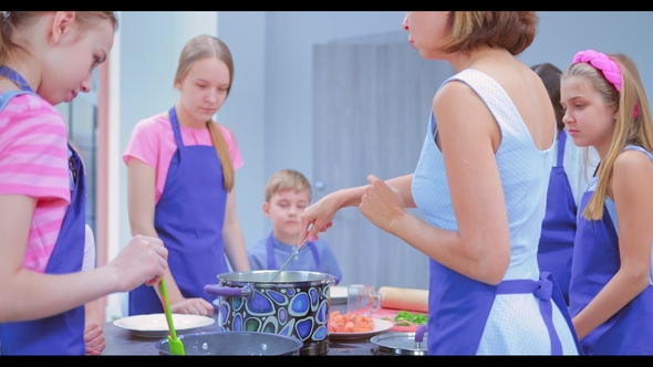 Young People Are Cooking. Children or Teenagers with a Woman in the Kitchen Prepare Food