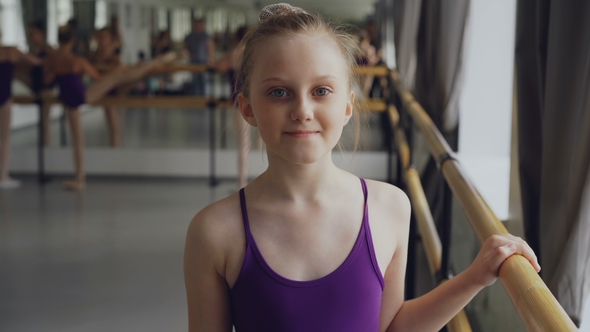 Portrait of Beautiful Little Girl Starting Ballet-dancer Looking at Camera and Smiling Standing