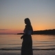 Beautiful Silhouette Pregnant Girl at Sunset Goes on Beach - VideoHive Item for Sale
