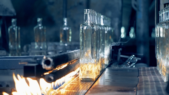 Industrial Press Is Removing Glass Bottles From the Transporting Belt During Annealing