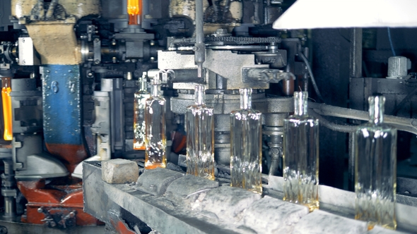 Newly-shaped Glass Bottles Are Relocating From the Glass-forming Machine Onto the Conveyor Belt