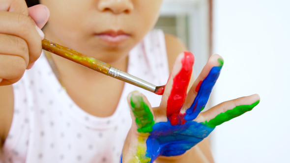 Asian child painting her hand