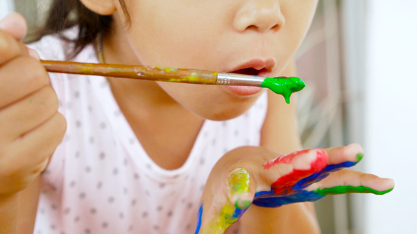 Asian child painting her hand