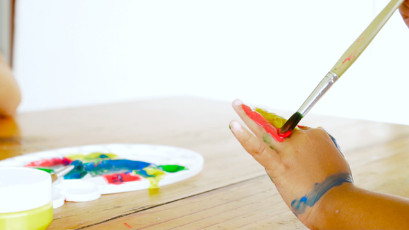 Asian child painting her hand