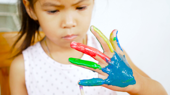 Asian child painting her hand