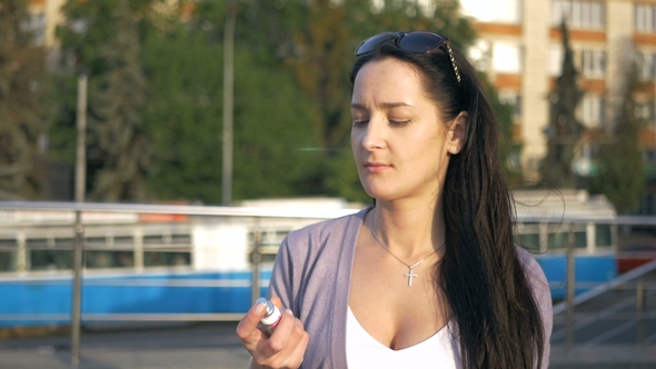 Brunette Freshens Her Breath with a Can for Mouth. The Girl Watches the Hygiene of the Mouth After