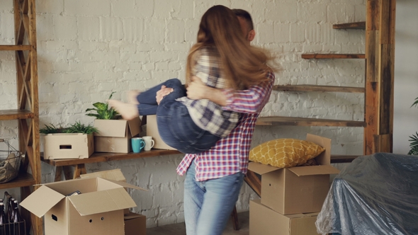 Cheerful Strong Guy Is Whirling His Girlfriend and Kissing Her While Moving To New House