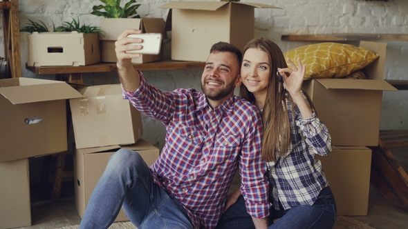 Happy Couple Is Taking Selfie with House Keys After Purchasing New Apartment. Young People Are