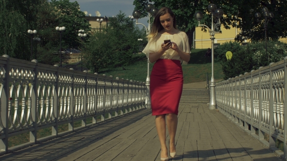 Stylish Woman Using Smart Phone App on City Bridge