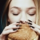 Delicious Fast Food. Aroma of Food. A Slender and Young Girl Holds a Hamburger. She Enjoys His Scent - VideoHive Item for Sale
