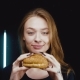 The Girl Is Holding a Hamburger. She Enjoys His Scent. - VideoHive Item for Sale