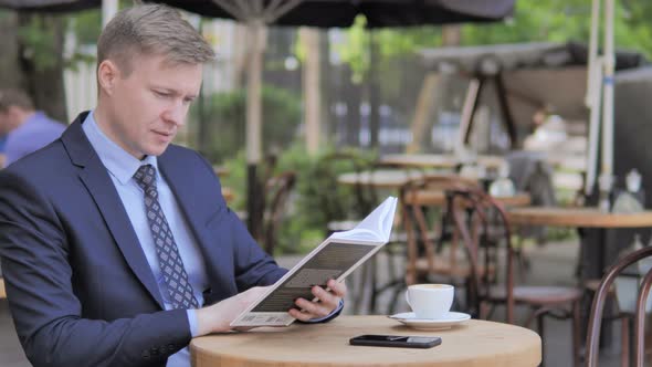 Outdoor Sitting Businessman Reading Book