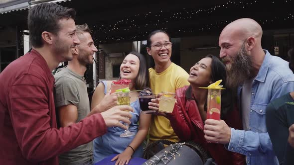 Funny Multicultural Group Of Friends Enjoying Evening Drinks In Bar