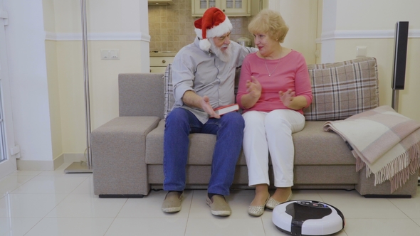 Elderly People Observes After Robot Vacuum Cleaner Sitting on Sofa at Home
