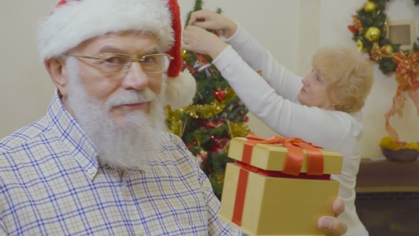 Senior Man Wearing Santa Hat Want To Make Suprise for His Wife