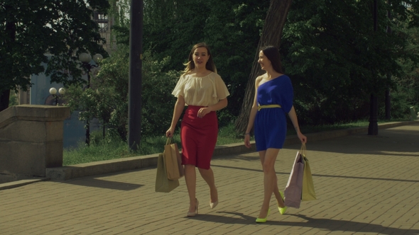 Happy Women with Shopping Bags Walking on the Street